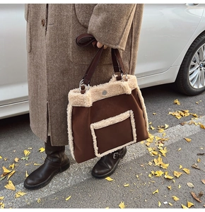 Detail of faux shearling trim and brown suede tote bag in autumn outdoor setting