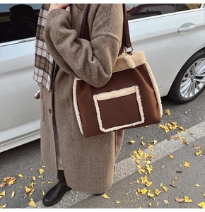 Detail of brown suede tote bag with plush faux shearling trim and long shoulder straps