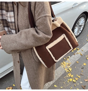 Outdoor shot of brown suede tote bag with faux shearling trim and leather handles