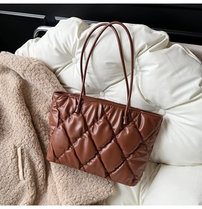 Detailed close-up of dark brown quilted tote bag showing its glossy padded texture