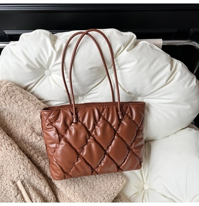Detail of large dark brown quilted puff tote bag in shiny PU leather with rhombic pattern