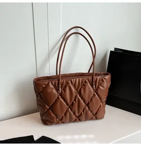 Close-up of brown quilted tote bag showing textured diamond pattern and PU leather finish