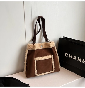 Detail of brown suede tote bag with faux shearling trim and dark leather straps
