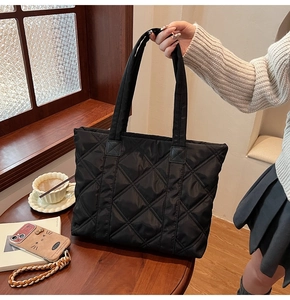 Detail of black quilted nylon tote bag showing the large capacity and padded texture