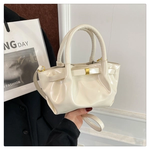 Detail of off-white leather handbag with gold buckle and pleated texture design