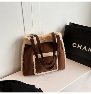 Close-up of brown suede tote with white faux shearling trim and leather handles