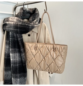 Detail of beige quilted tote bag showing fine stitching and matte leather texture