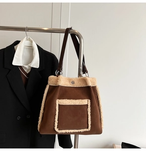 Detail of faux shearling trim on dark brown suede tote bag with shoulder straps
