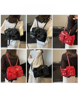 Detail view of large shoulder bag with bows in black and red showing dual strap options