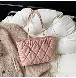 Detailed close-up of a pink quilted tote bag showing rhombus texture and puffer style