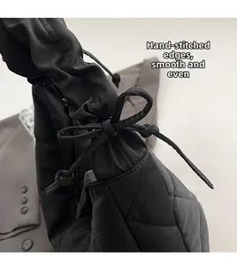Close-up of black quilted nylon tote bag with drawstring bow and stitching details