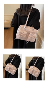 Detail of pink PU leather tote with front bow pockets and glossy finish on shoulder strap
