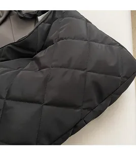 Detail shot of black quilted tote bag showing soft nylon fabric and diamond texture
