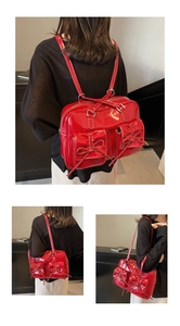Detail of red patent leather bag with bow knots and dual front pocket design
