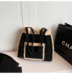 Close-up of black matte tote bag featuring beige faux shearling trim and pocket detail