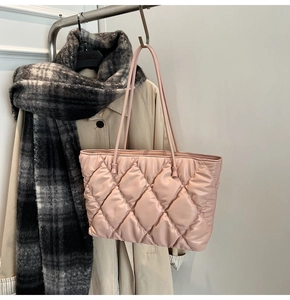 Side view of a pink quilted tote bag with thin straps showing its large capacity