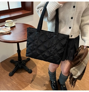 Dettaglio di una borsa tote in nylon trapuntato nero con motivo a rombi in interni