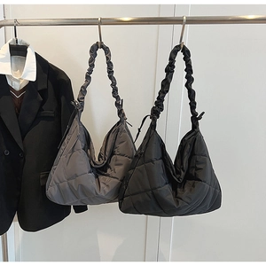 Close-up of black and grey quilted tote bags featuring stylish pleated shoulder straps