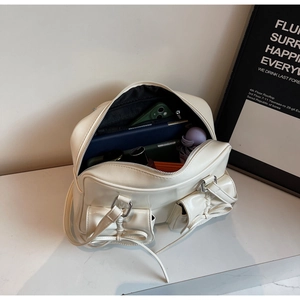Spacious interior of the cream bow tote bag showing daily items like a phone and umbrella