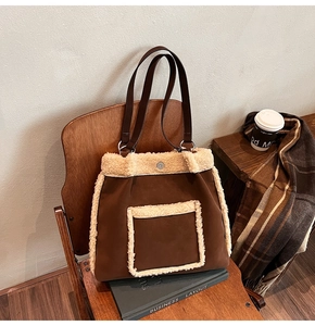 Close-up of brown faux suede tote bag with cream fleece trim on a vintage chair