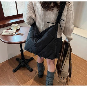 Detailed view of black quilted nylon bag featuring a large capacity and bow-tied strap