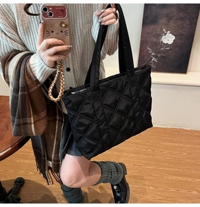 Chic black quilted tote bag for women showing spacious capacity in a winter outfit setting