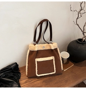 Detail of faux shearling trim and brown suede tote bag in a cozy winter setting