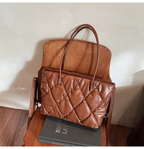 Macro shot of brown quilted tote bag material on vintage wooden chair setup