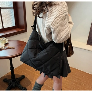 Detail of the black quilted nylon tote bag showing its large capacity and soft texture
