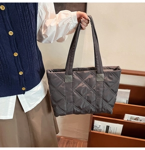 Dettaglio della borsa tote in nylon trapuntato con ricamo a rombi e tracolla resistente