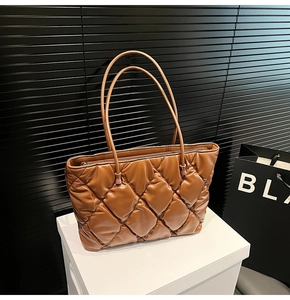 Close-up of brown quilted faux leather tote bag with elegant diamond stitch pattern