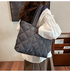 Dettaglio della grande borsa tote in nylon grigio trapuntato con cuciture a rombi