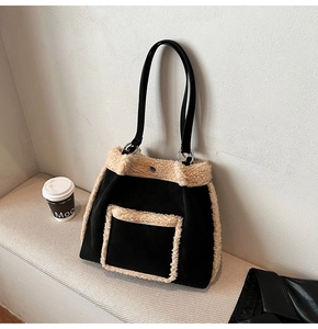 Detailed view of the black suede tote with cream sherpa trim and leather strap