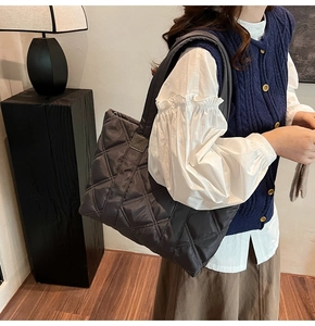 Deep grey quilted tote bag shown on shoulder for daily commute and urban style