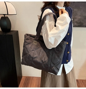 Borsa tote in nylon trapuntato con cuciture a rombi in un ambiente interno moderno