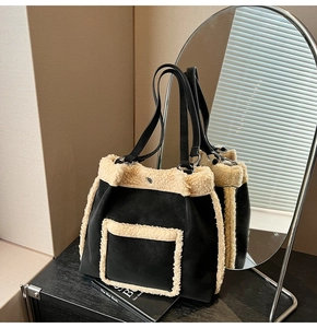 Detail of plush lamb wool stitching on black matte tote bag with slim shoulder straps