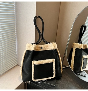 Detail of faux shearling trim and matte black material on a commuter shoulder bag