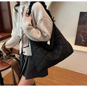 Detail of black quilted nylon dumpling bag with pleated drawstring shoulder strap