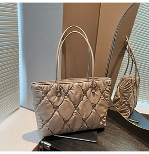 Detail of quilted beige tote bag showing high-quality padded texture and diamond stitching
