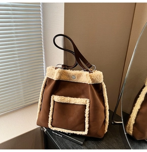 Detail of plush lamb wool trim on large brown canvas tote bag with leather straps