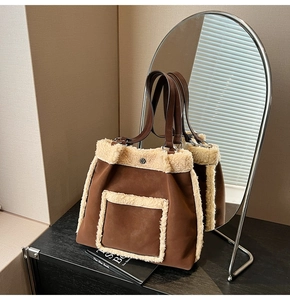 Detail of faux shearling stitching and suede material on a brown commuter tote bag
