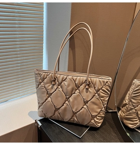 Detail of leaf pattern quilted tote bag in beige with silky fabric and slim straps