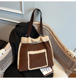 Close-up of brown suede tote bag with beige fleece trim and leather shoulder straps