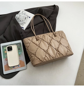 Close-up of khaki quilted tote bag with soft leather texture and elegant handles