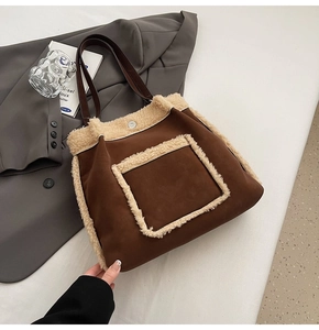 Close-up of brown suede tote bag featuring cream shearling trim and front pocket detail