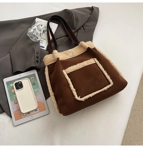 Detailed shot of brown suede tote bag featuring plush faux fur trim and magnetic silver buckle