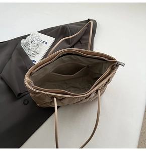 Top-down macro view of quilted tote bag interior with zipper pocket and large capacity