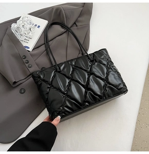 Macro shot of black quilted tote bag texture with sleek PU leather finish and strap detail