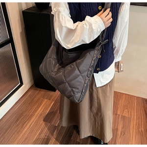 Detail of large dark grey quilted nylon dumpling bag showing chic diamond stitching