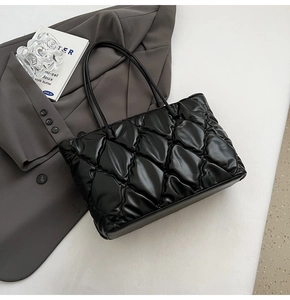 Close-up of black quilted leather tote bag with fine stitching and soft padded finish
